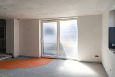 Tamamlanmamış Modern Mutfak İçi Büyük Patio Kapısı, Beyaz Duvarlar, Turuncu Döşeme Hazırlığı ve Buzlu Cam Pencerelerden Doğal Işık