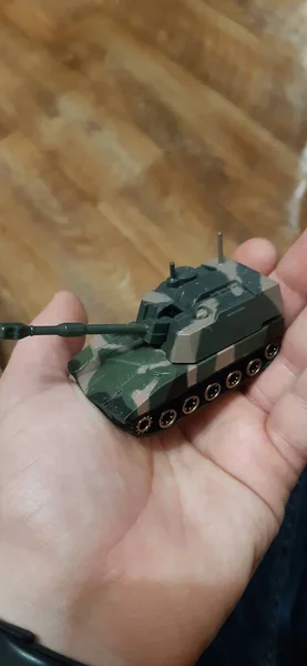 A small collectible plastic figure of a tank in military camouflage