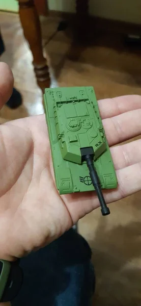 A small collectible plastic figure of a green tank