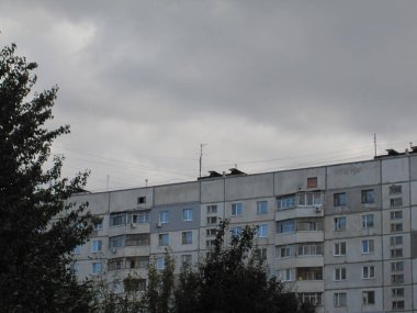 Yerleşim yerlerinin ve yeşil ağaçların üzerindeki bulutlu gökyüzü