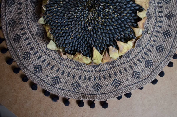 黒い装飾が施された織り麻ナプキンの背景に種子でひまわりを乾燥させます 静物ヴィンテージ村の写真 — ストック写真