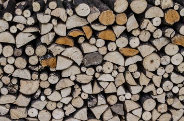 Bölünmüş, kurumuş ve yakacak odun yığınlarının arka planı. Bir odun parçası..