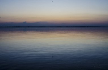 Deniz kıyısında günbatımı. Su elementinin fotoğraf uyumu.