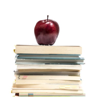 bir yığın kitap üzerine kırmızı elma