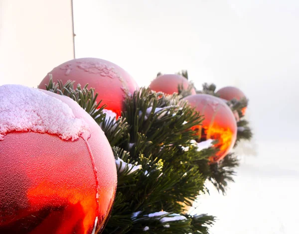 Detail of the ice and snow above the red spheres of the Christmas decorations