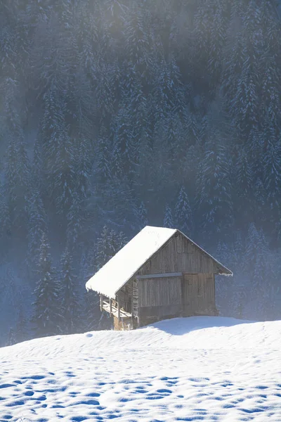 an old log cabin in a snow covered winter landscape