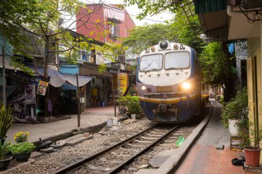 Hanoi, Vietnam, January 2023.  the passage of a train along the tracks between the houses of the old district of the city centre