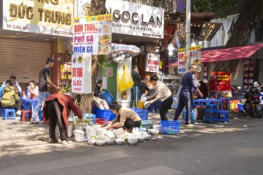 Hanoi, Vietnam, January 2023.  washing dishes on the street of a small restaurant in the city center