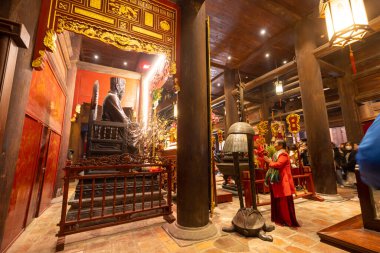 Hanoi, Vietnam, January 2023.  the faithful in prayer inside the temple of literatur