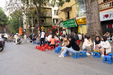 Hanoi, Vietnam, January 2023. people sitting at the outdoor cafe on the street in the city center