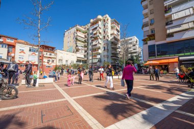 Tiran, Arnavutluk. 2023 Mart 'ında güneşli bir günde şehir merkezinin sokaklarında yürüyen insanlar.