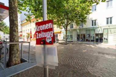 Villach, Avusturya. 18 Temmuz 2023. Avusturya gazetesi Kronen Zeitung 'un şehir merkezindeki bir direğin üzerindeki dağıtımcısının görüntüsü.