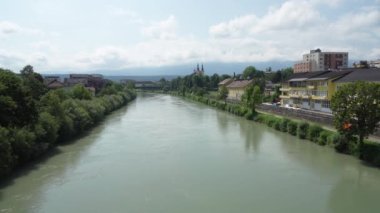 Villach, Avusturya. 18 Temmuz 2023. Şehir merkezindeki Drava nehrinin panoramik manzarası.