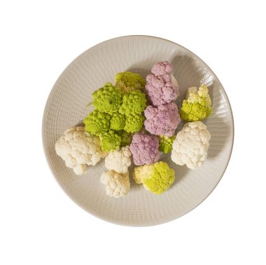 Beyaz, pembe ve yeşil karnabahar. Arka planda bir tabakta.