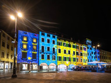 Udine, İtalya, Aralık 2023. Şehrin tarihi merkezinin binalarına Noel ışığı süslemeleri yansıtılıyor.