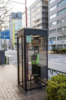 Tokyo, Japonya, Ocak 2024 şehir merkezindeki bir caddenin kaldırımında bir ankesörlü telefon kulübesi.