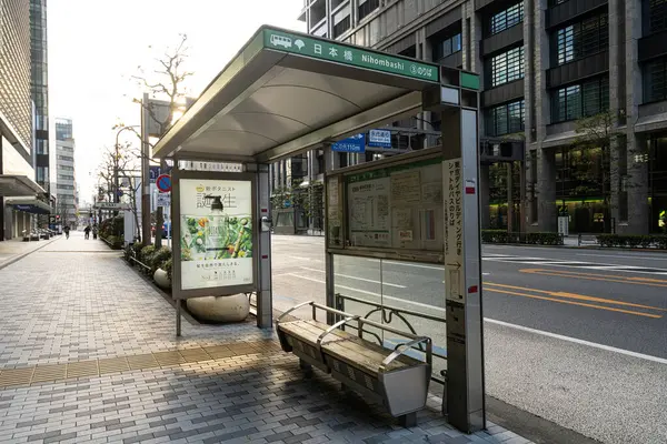 Tokyo, Japonya, Ocak 2024. Şehir merkezindeki bir caddenin kaldırımındaki otobüs durağının kapalı sığınağı.