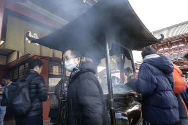 Tokyo, Japonya. Ocak 2024. Şehir merkezindeki Senso ji Tapınağı 'nın önündeki tütsü ocağına sadık..