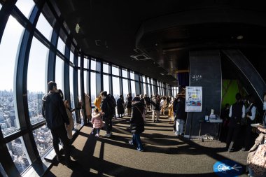 Tokyo, Japonya. 9 Ocak 2024 'te şehir merkezindeki Tokyo Kulesi' ndeki ara gözlemevinden şehir panoramasına bakan insanlar görülüyor.