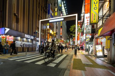 Tokyo, Japonya. 9 Ocak 2024. Şehir merkezindeki Musashino Caddesi 'nin ışıkları arasında yürüyen insanların gece görüntüsü.