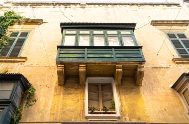 Valletta, Malta, Nisan 03, 2024. Şehir merkezindeki eski binaların tipik ahşap balkon manzarası.
