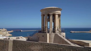 Valletta, Malta, 3 Nisan 2024. Arka planda Ricasoli Doğu Dalgakıranı 'nın bulunduğu Kuşatma Çanı Savaşı Anıtı. ..