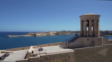 Valletta, Malta, 3 Nisan 2024. Arka planda Ricasoli Doğu Dalgakıranı 'nın bulunduğu Kuşatma Çanı Savaşı Anıtı. ..