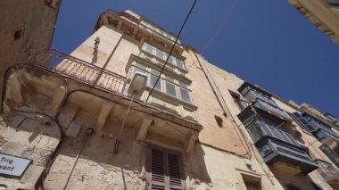 Valletta, Malta, Nisan 03, 2024. Şehrin tarihi merkezindeki karakteristik sokaklardaki eski evlerin manzarası.