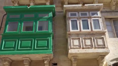 Valletta, Malta, Nisan 03, 2024 şehir merkezindeki eski binalardaki tipik renkli ahşap balkonların dış görünüşü.