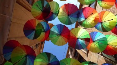 Bükreş, Romanya. 23 Mayıs 2024. Şehir merkezinin dar bir sokağında çok renkli şemsiyeler var.