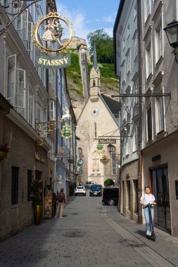 Salzburg, Avusturya. 1 Temmuz 2024 'te şehir merkezindeki Getreidegasse caddesindeki dükkan tabelalarının görüntüsü