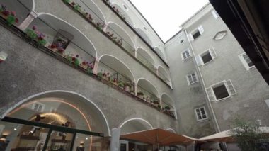Salzburg, Avusturya. 1 Temmuz 2024 'te balkonlar şehir merkezindeki binalar arasındaki bir avluda çiçek kutularıyla süslenmişti.