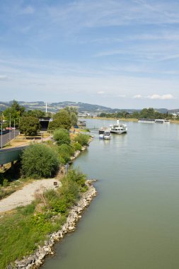 Linz, Avusturya. 12 Ağustos 2024 Tuna Nehri 'nin şehir merkezindeki kıyılarının panoramik manzarası.