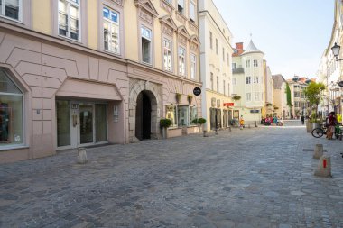Linz, Avusturya. 12 Ağustos 2024. Şehrin tarihi merkezinin eski binaları arasında bir cadde.