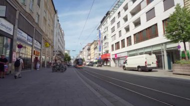 Linz, Avusturya. 12 Ağustos 2024. Şehir merkezindeki bir caddeden geçen bir tramvay.