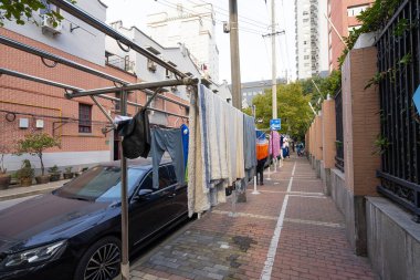 Şangay, Çin. 7 Ocak 2025. Giysiler şehir merkezindeki kaldırımda kurumaya bırakılmış.