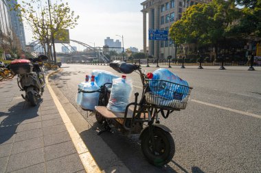 Şangay, Çin. 8 Ocak 2025. Şehir merkezindeki bir sokakta su bidonu dağıtımından motorlu taşıt.