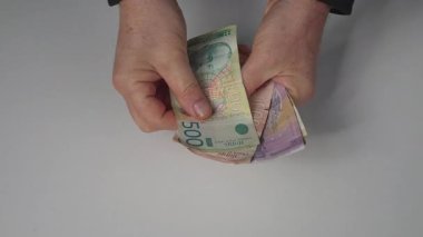 Masadaki Sırp dinar banknotlarını saymak