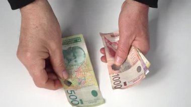 Masadaki Sırp dinar banknotlarını saymak