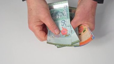 Masadaki bazı Malezya Halkaları banknotlarını saymak