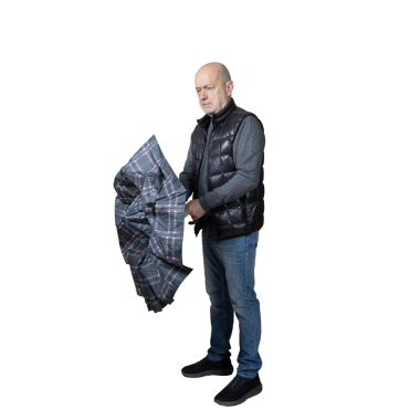 Bir adam şemsiyesini kapatıyor.