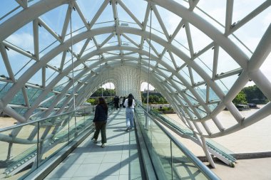 Tiflis, Georgia. 17 Mayıs 2025. Şehir merkezindeki Kura Nehri üzerindeki Barış Köprüsü 'nün panoramik görüntüsü.