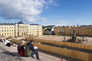 Helsinki, Finlandiya. 26 Ağustos 2025. Bazı turistler şehrin katedralinin önündeki merdivenlerde oturuyorlar.