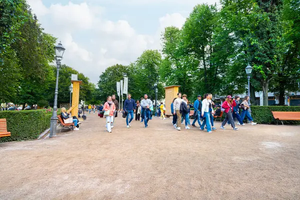 Helsinki, Finlandiya. 26 Ağustos 2025. Şehir merkezindeki Esplanadi Parkı boyunca yürüyen insanlar