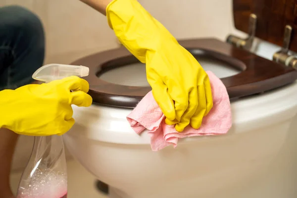 黄色のゴム手袋の女性の手は ラグを保持している洗剤と消毒剤でトイレを拭く 女は浴室を掃除してる — ストック写真