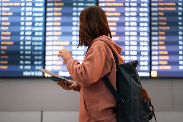 少女は空港で飛行機に乗り パスポートとチケットを手に持って 飛行機を探してゲート番号を見て 女性はバックパックで旅行に行く — ストック写真