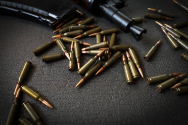 AKS-74U saldırı tüfeği ve 5.45 'lik fişekler karanlık bir arka planda, şarjörlü bir ateşli silah, askeri tema ve silahlarla ilgili bir konsept..