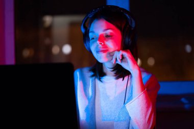 Genç bir kız kulaklık tutuyor, müzik dinliyor ve beste yapıyor, bir kadın odasının penceresinde dizüstü bilgisayarıyla oturuyor, çalışıyor ve sesten zevk alıyor..