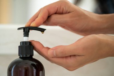 Kız ellerini suyun altında sıvı sabunla yıkıyor, kadın sağlığıyla ve temizliğiyle ilgileniyor, ellerini dezenfekte ediyor..