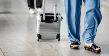 Bir grup insan bavulları, bavulları ve çantalarıyla havaalanındaki kontrol noktasına uçuştan önce tren istasyonunda yürüyorlar. Bir erkek ve bir kadın seyahate çıkıyorlar, taşınıyorlar, seyahat ediyorlar..